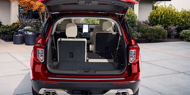Red SUV with its hatch open, showing folded third-row seats for expanded cargo space.