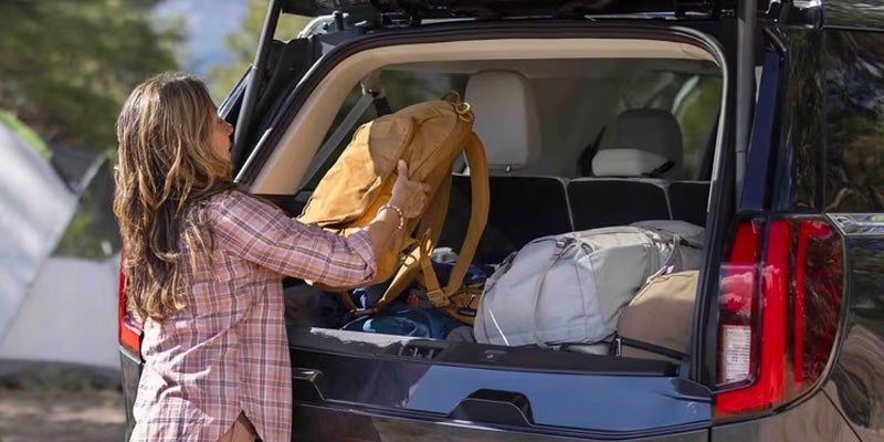 Loading luggage into the SUV cargo area.