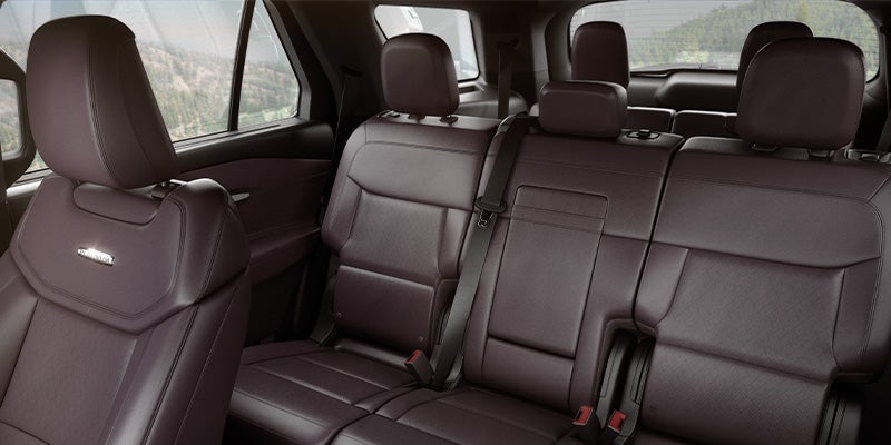 Car interior with dark purple leather seats, showing the second and third rows