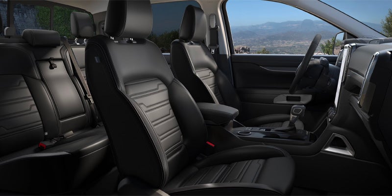 Spacious Ford pickup truck interior featuring black leather seats, center console, dashboard controls