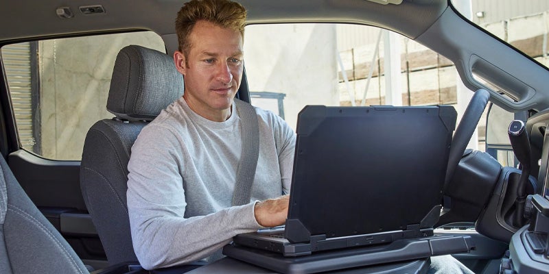 Truck occupant using a laptop inside the vehicle.