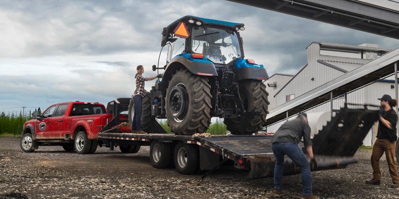 Trailer transporting heavy equipment behind a truck.