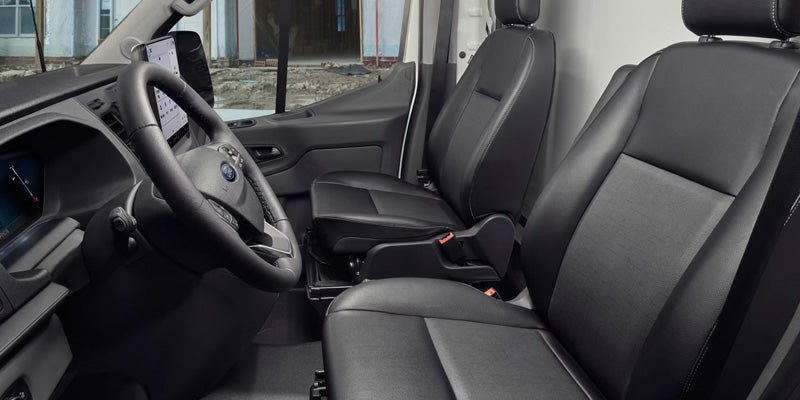 Driver's perspective of a vehicle interior showing black leather seats, steering wheel, and a large central touchscreen.