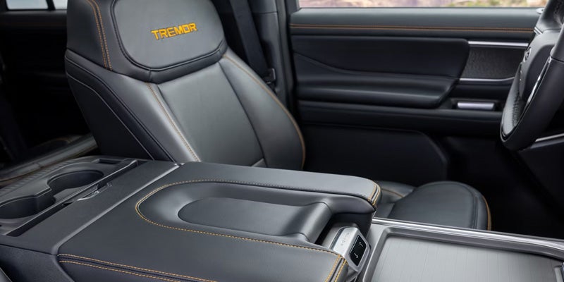 Black leather car interior with TREMOR embroidered seat, orange stitching