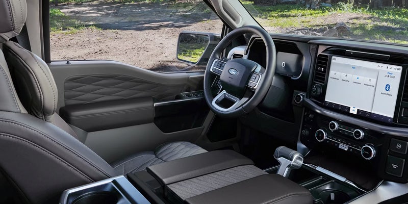 Modern truck cabin featuring the steering wheel and front seating area.