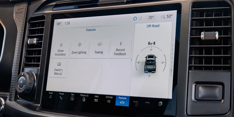 Vehicle touchscreen displaying connected vehicle features and controls.