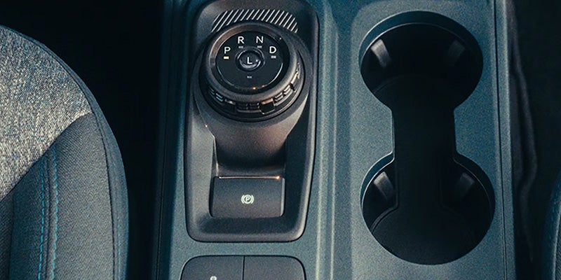 Vehicle center console featuring a rotary gear selector.