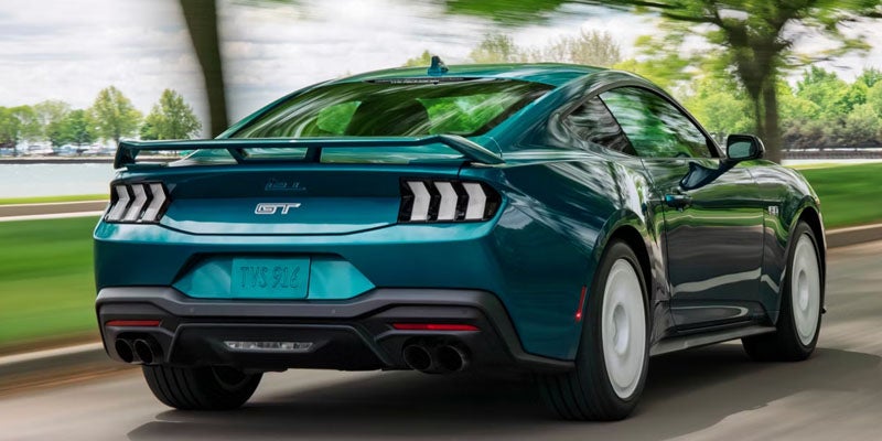 Rear view of a Ford Mustang GT driving on the road.