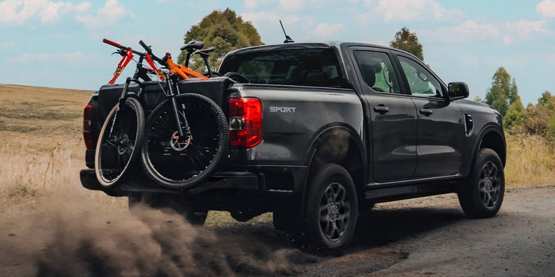 Pickup truck carrying bicycles on a rear-mounted bike rack.