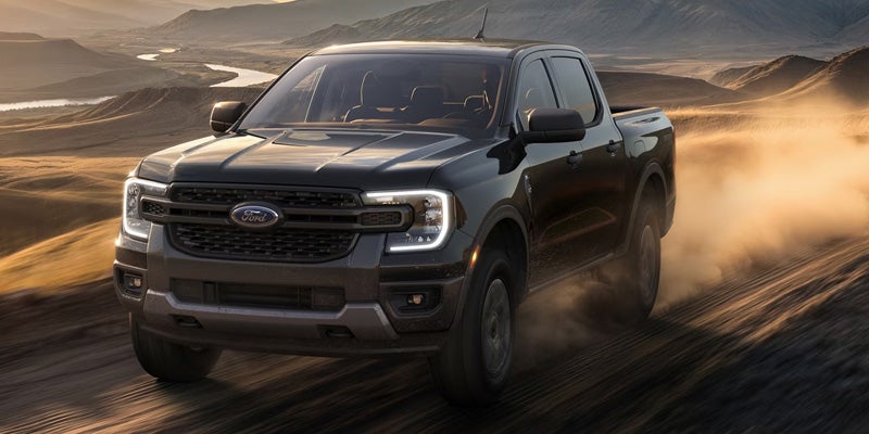 Black Ford Ranger driving on a road.
