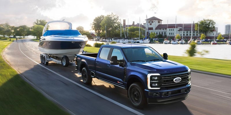 Ford Super Duty truck towing a trailer on the road.