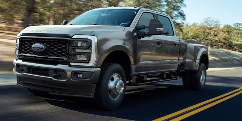 Gray Ford Super Duty truck driving on a roadway.