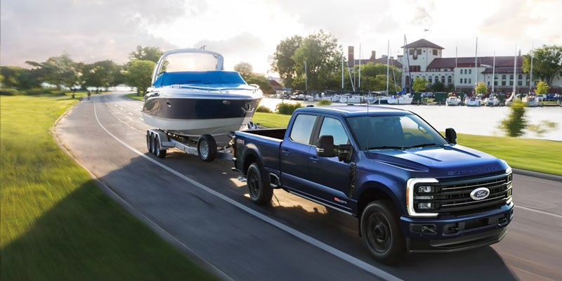 Ford Super Duty towing a boat on the road.