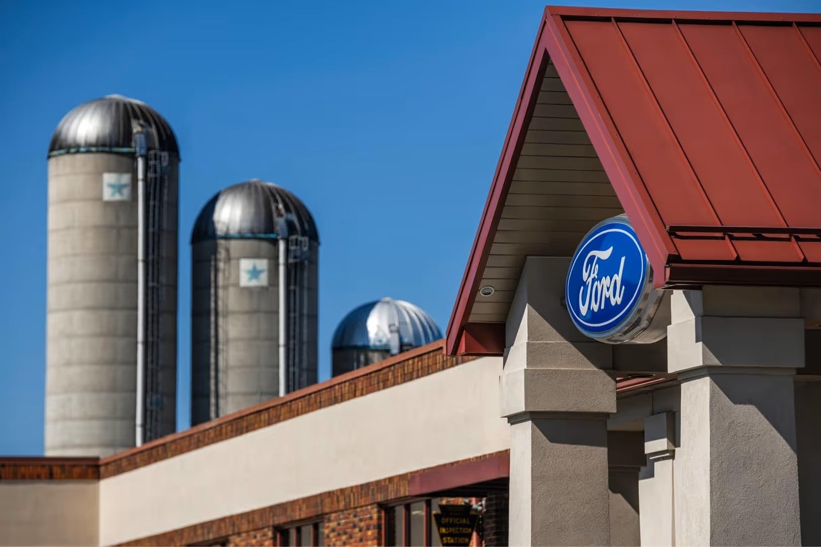 Ford dealership building with silos in the background