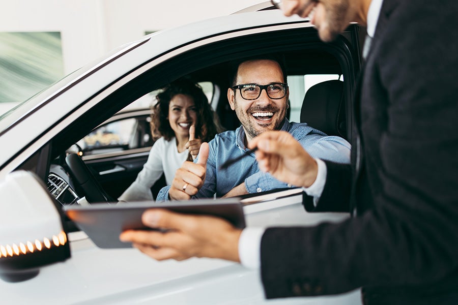 Customer receiving car keys at a dealership.